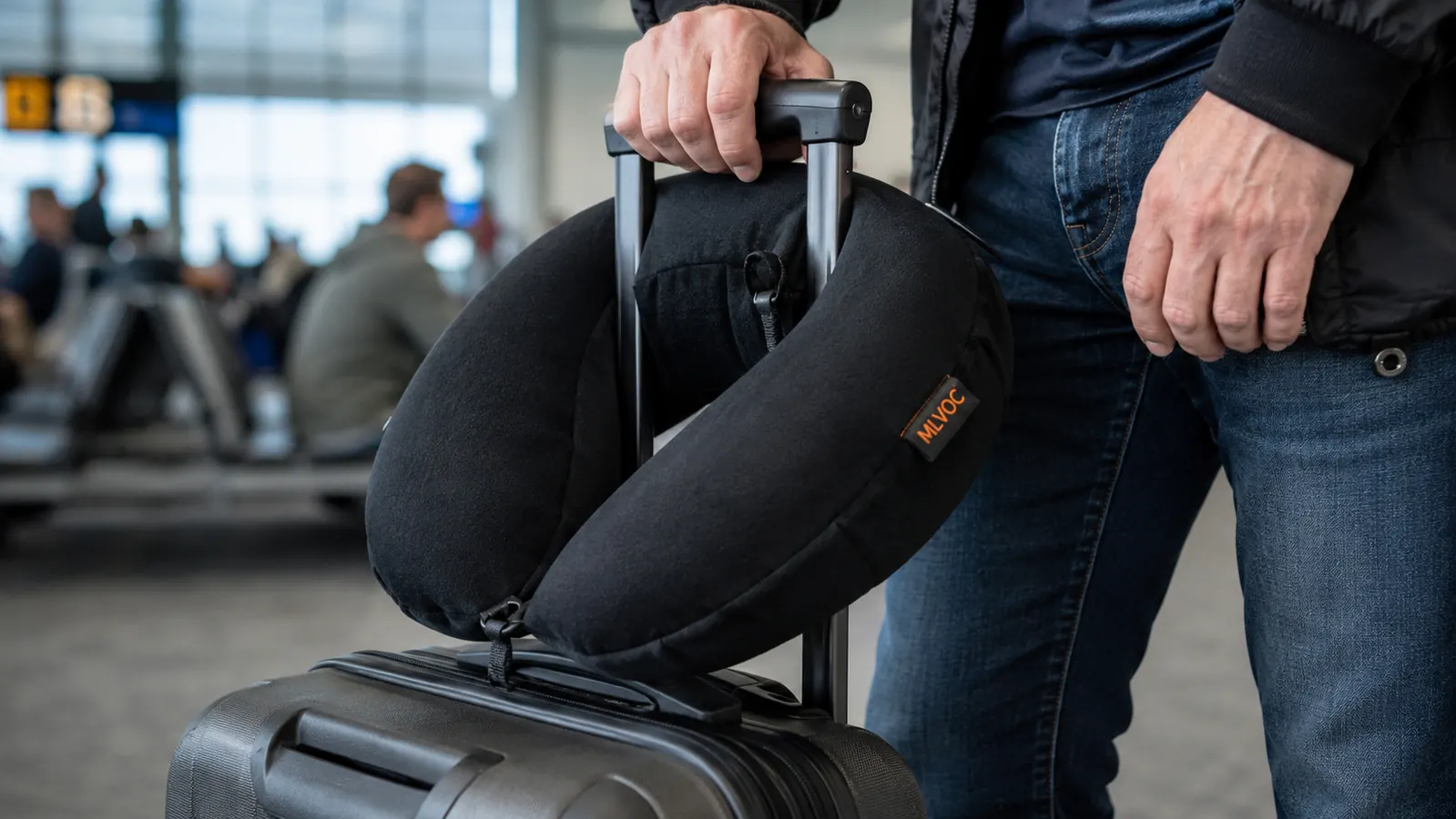 MLVOC memory foam travel pillow shown on a carry-on bag handle at an airport gate